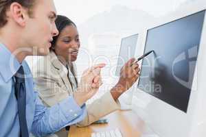 Business colleagues using computers at desk