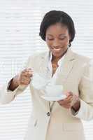 Elegant smiling businesswoman with tea cup in office