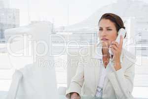 Businesswoman using computer and phone