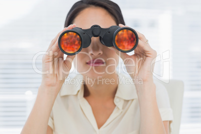 Close-up of a businesswoman looking through binoculars