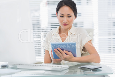 Businesswoman using digital tablet at desk