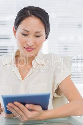 Businesswoman using digital tablet at desk