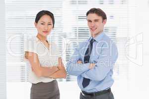 Business colleagues with arms crossed in office