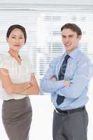 Business colleagues with arms crossed in office