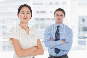 Business colleagues with arms crossed in office