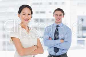 Business colleagues with arms crossed in office