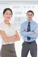 Business colleagues with arms crossed in office