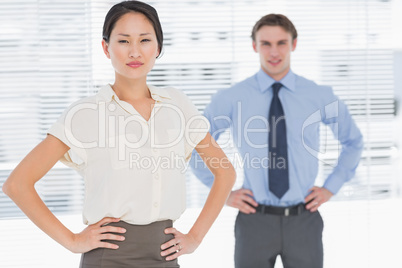 Business colleagues with hands on hips in office