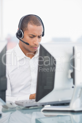 Executive with headset using computer at desk
