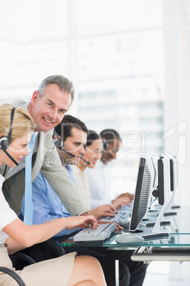 Manager and executives with headsets using computers