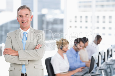 Happy businessman with executives using computers in office