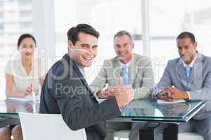 Executive gesturing thumbs up with recruiters during job intervi
