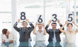 Group of panel judges holding score signs