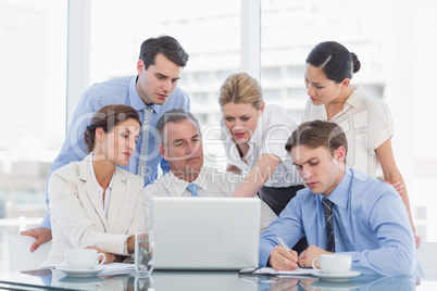 Business colleagues with laptop at desk