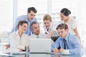 Business colleagues with laptop at desk