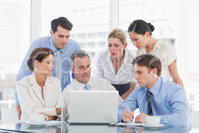 Business colleagues with laptop at desk