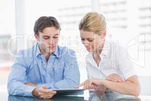 Businessman and woman using digital tablet in office
