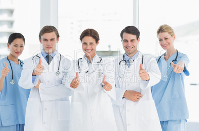 Doctors gesturing thumbs up at hospital