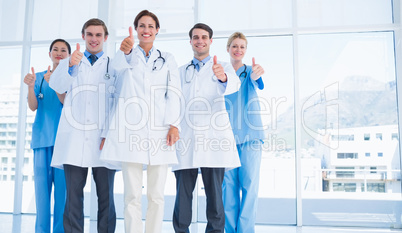 Doctors gesturing thumbs up at hospital