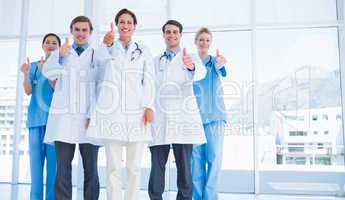 Doctors gesturing thumbs up at hospital