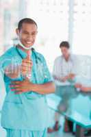 Surgeon gesturing thumbs up with group around table in hospital