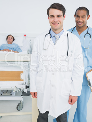 Two smiling doctors with patient in hospital