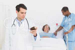 Doctor holding a bottle of pills with patient in hospital