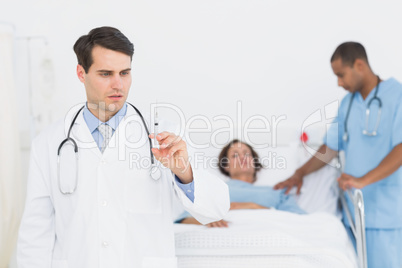 Doctor holding a syringe with patient in hospital