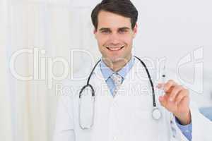 Portrait of a handsome doctor holding an injection