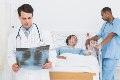 Doctor examining x-ray with patient in hospital