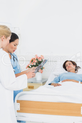 Doctor and surgeon visiting female patient