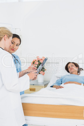 Doctor and surgeon visiting female patient