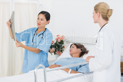 Doctors examining x-ray with patient in hospital