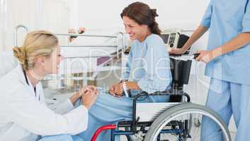 Doctor talking to patient in wheelchair at hospital