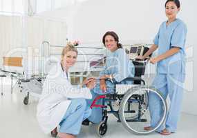 Doctors with female patient in wheelchair at hospital