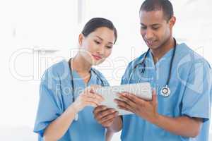 Surgeons looking at digital tablet in hospital