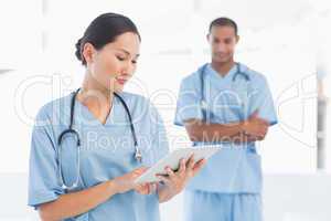 Beautiful female surgeon holding digital tablet