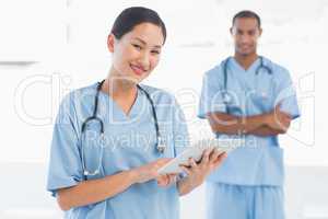 Beautiful surgeon holding digital tablet in hospital