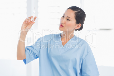 Serious doctor holding an injection in hospital