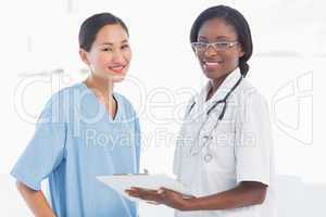 Female doctor and surgeon with report in hospital