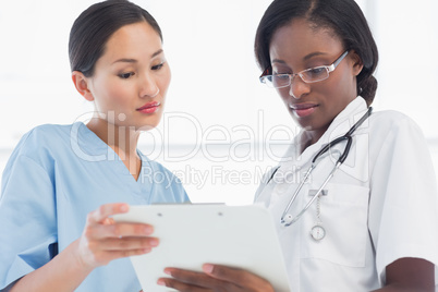 Female doctor and surgeon looking at report