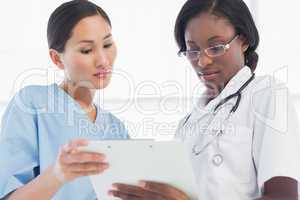 Female doctor and surgeon looking at report