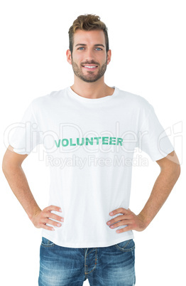 Portrait of a happy male volunteer standing with hands on hips