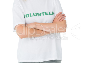 Mid section of a female volunteer standing with arms crossed