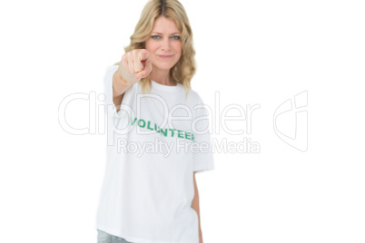 Portrait of a happy female volunteer pointing at you