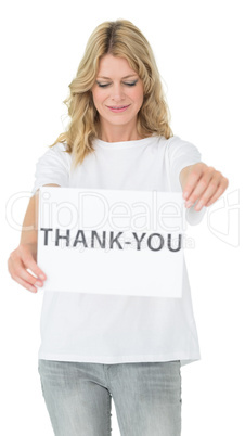 Smiling female volunteer holding 'thank you' paper