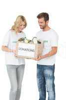 Smiling young couple carrying donation box