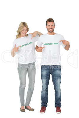 Portrait of two happy volunteers pointing to themselves