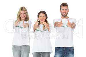 Portrait of happy three volunteers gesturing thumbs up