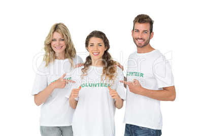 Portrait of happy volunteers pointing to friend